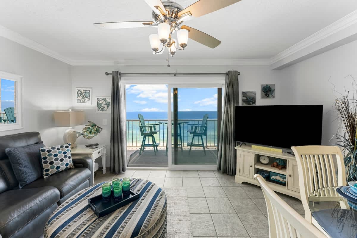 The Summit 1130 – Cozy living room with a balcony view of the ocean and seating for two.