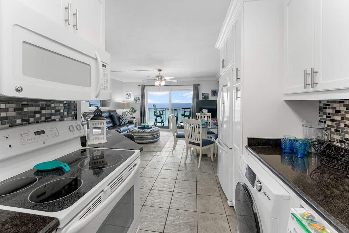 The Summit 1130 – Bright open kitchen leading to a living area with ocean view and dining table.