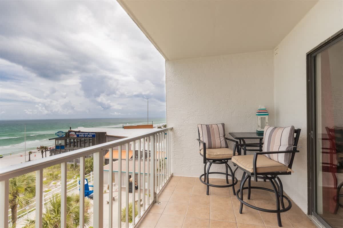The Summit 504 – Balcony with two high chairs and a table, overlooking the beach and ocean.