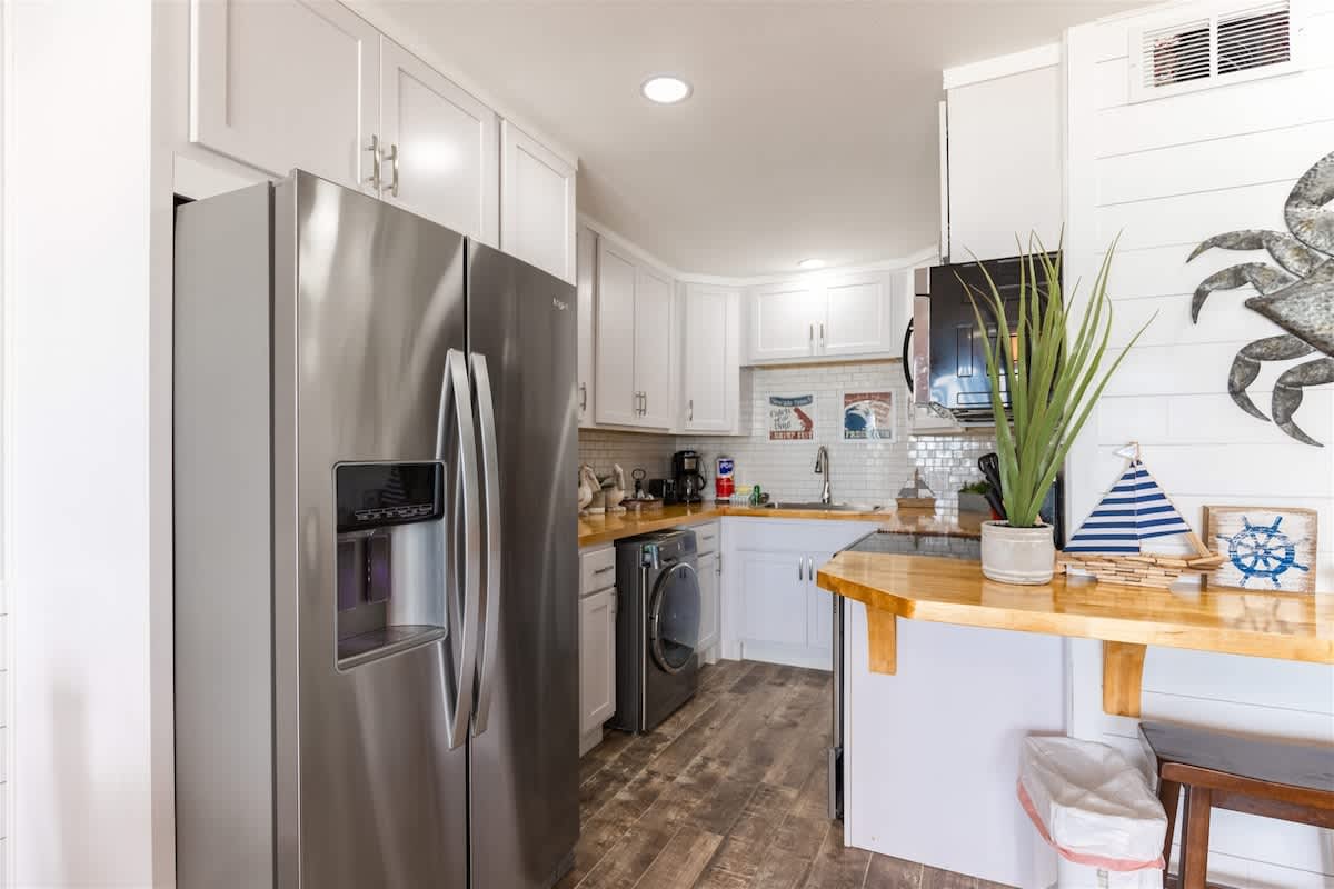 The Summit 504 – Modern kitchen with stainless steel appliances, wood countertop, and decorative nautical elements.