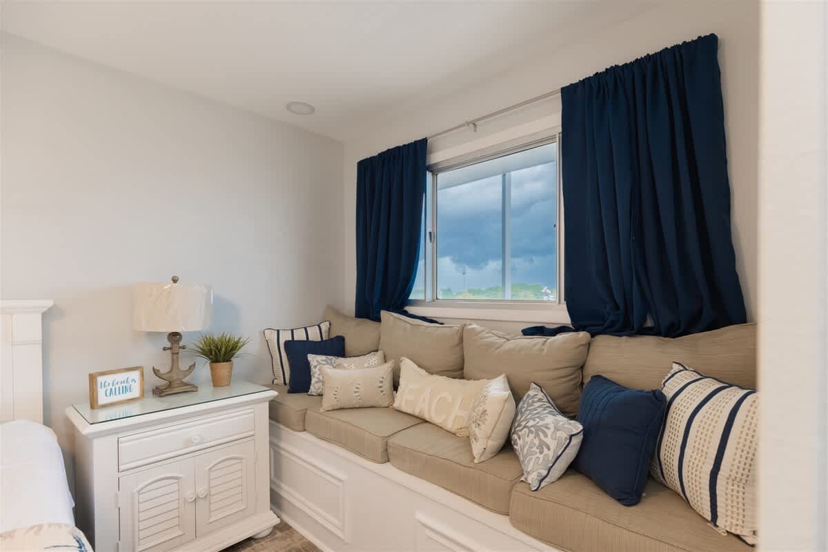 The Summit 504 – Cozy seating area with cushions, window, decorative lamp, and a small table.