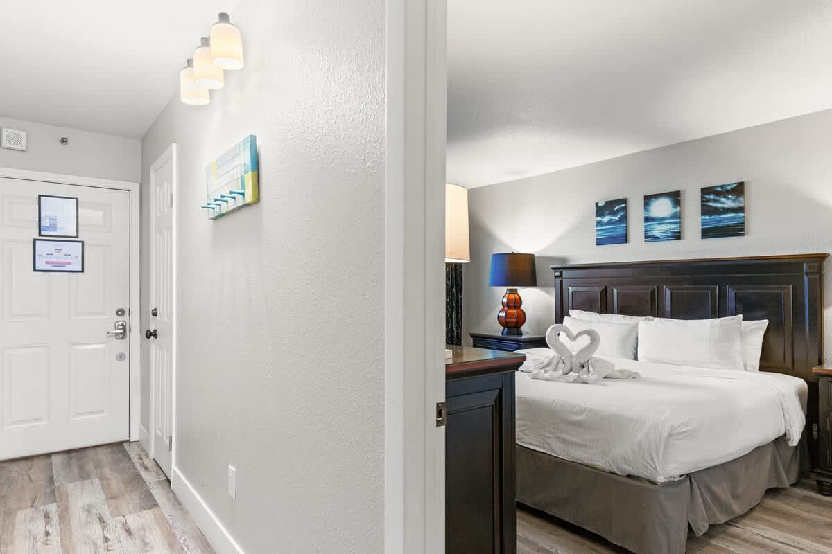 The Summit 515 – Cozy bedroom with a king bed, nightstands, lamp, and decorative wall art.