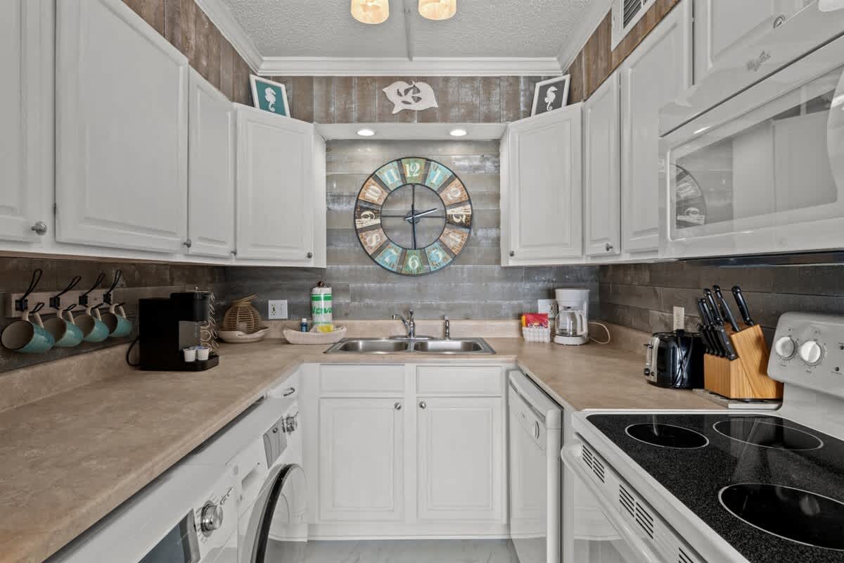 The Summit 816 – Compact kitchen with white cabinetry, clock feature, appliances, and countertop space.