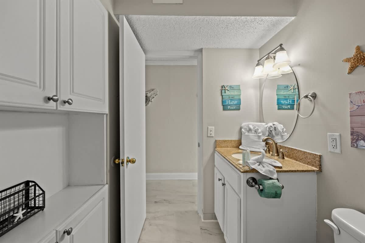 The Summit 816 – Bathroom with a single vanity, mirror, light fixture, and decorative wall art.