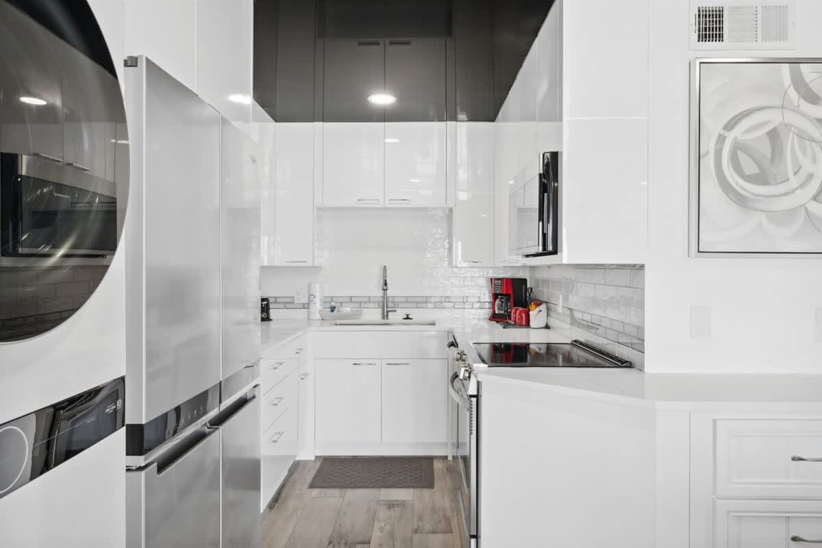 The Summit 702 – Modern kitchen with white cabinetry, stainless steel appliances, and a coffee maker on the counter.