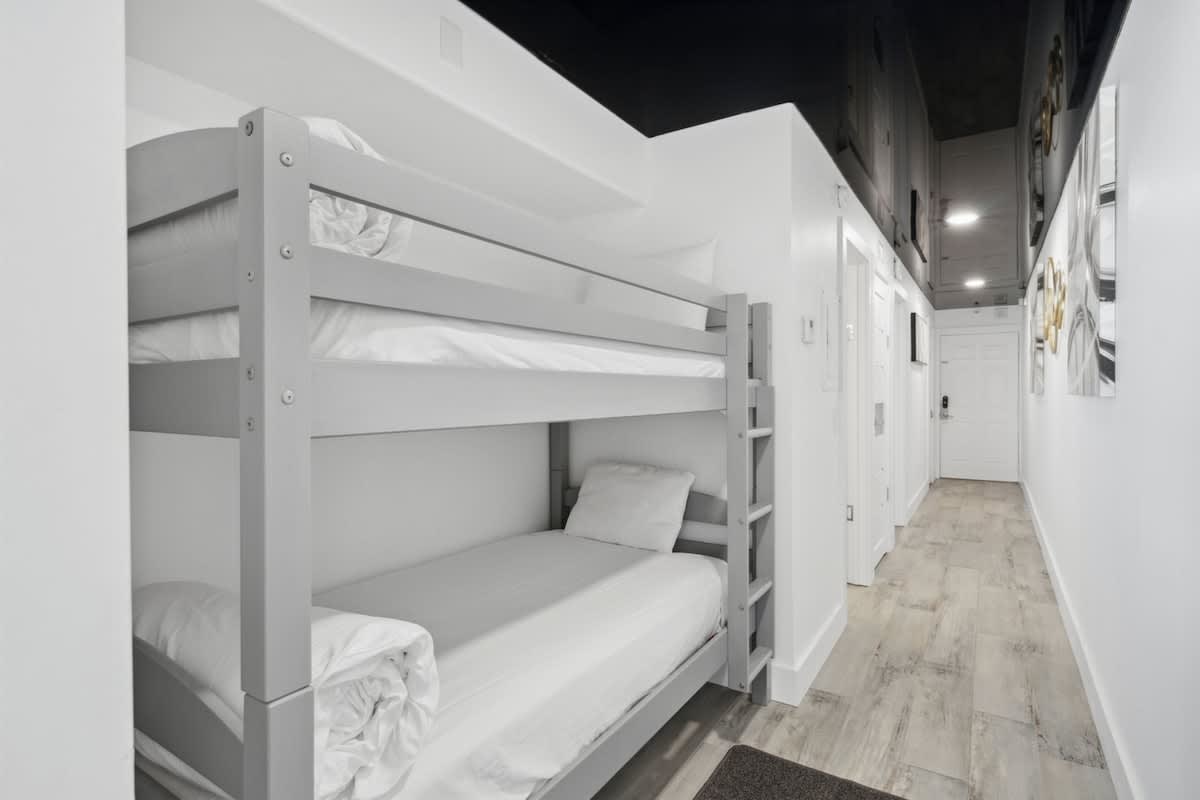 The Summit 702 – Bunk bed in a narrow hallway with white walls and light wood flooring.