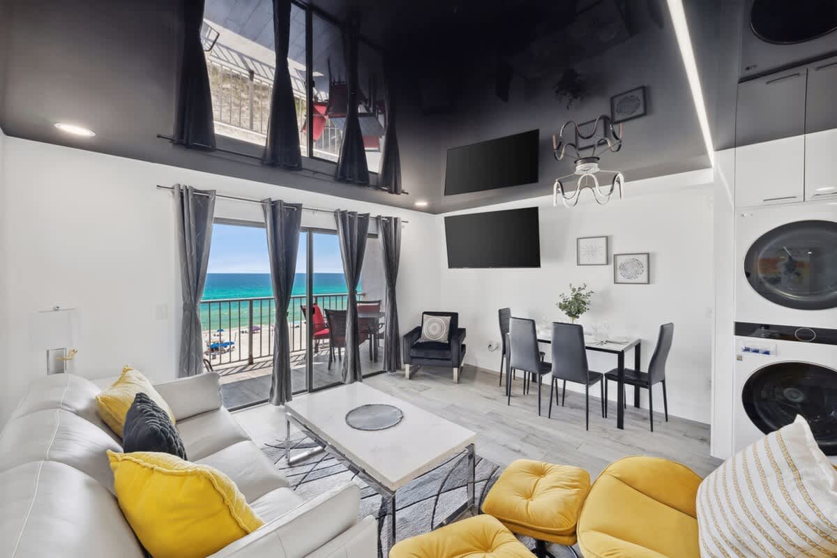 The Summit 702 – Open living area with ocean view, modern furniture, dining table, and balcony access.