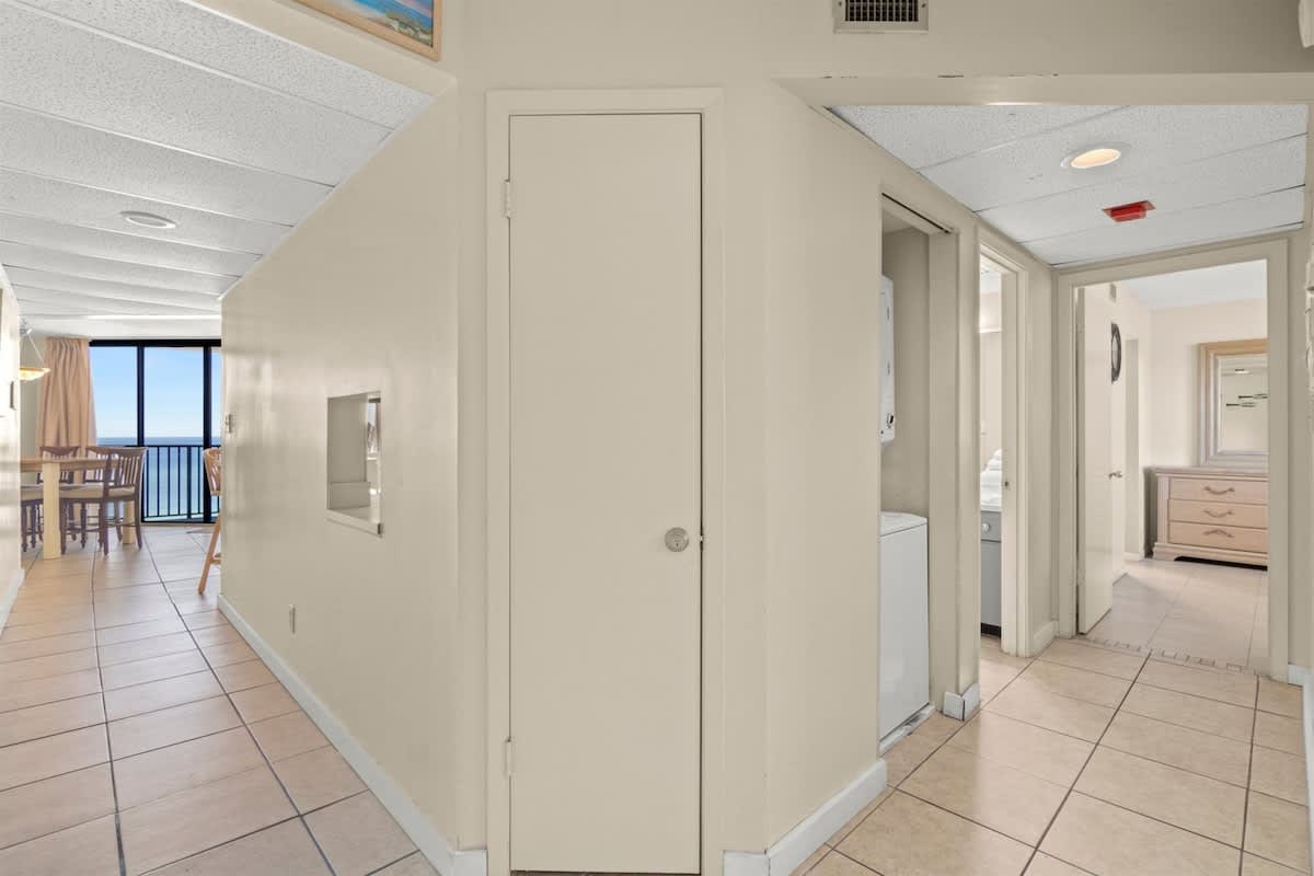 Aquavista 405e – Hallway leading to dining area with ocean view, laundry room, and bathroom doorways.
