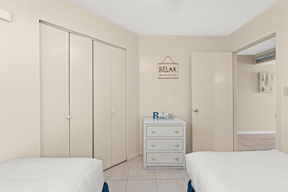 Aquavista 405e – Interior of a bedroom with two beds, dresser, closet, and a "RELAX" sign on the wall.