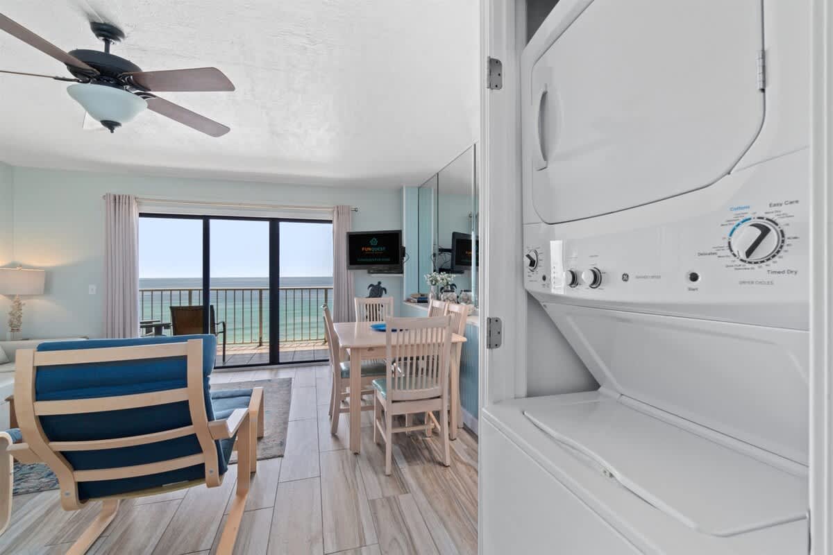 The Summit 1030 – Living area with ocean view, dining table, washer-dryer unit, and modern furnishings.