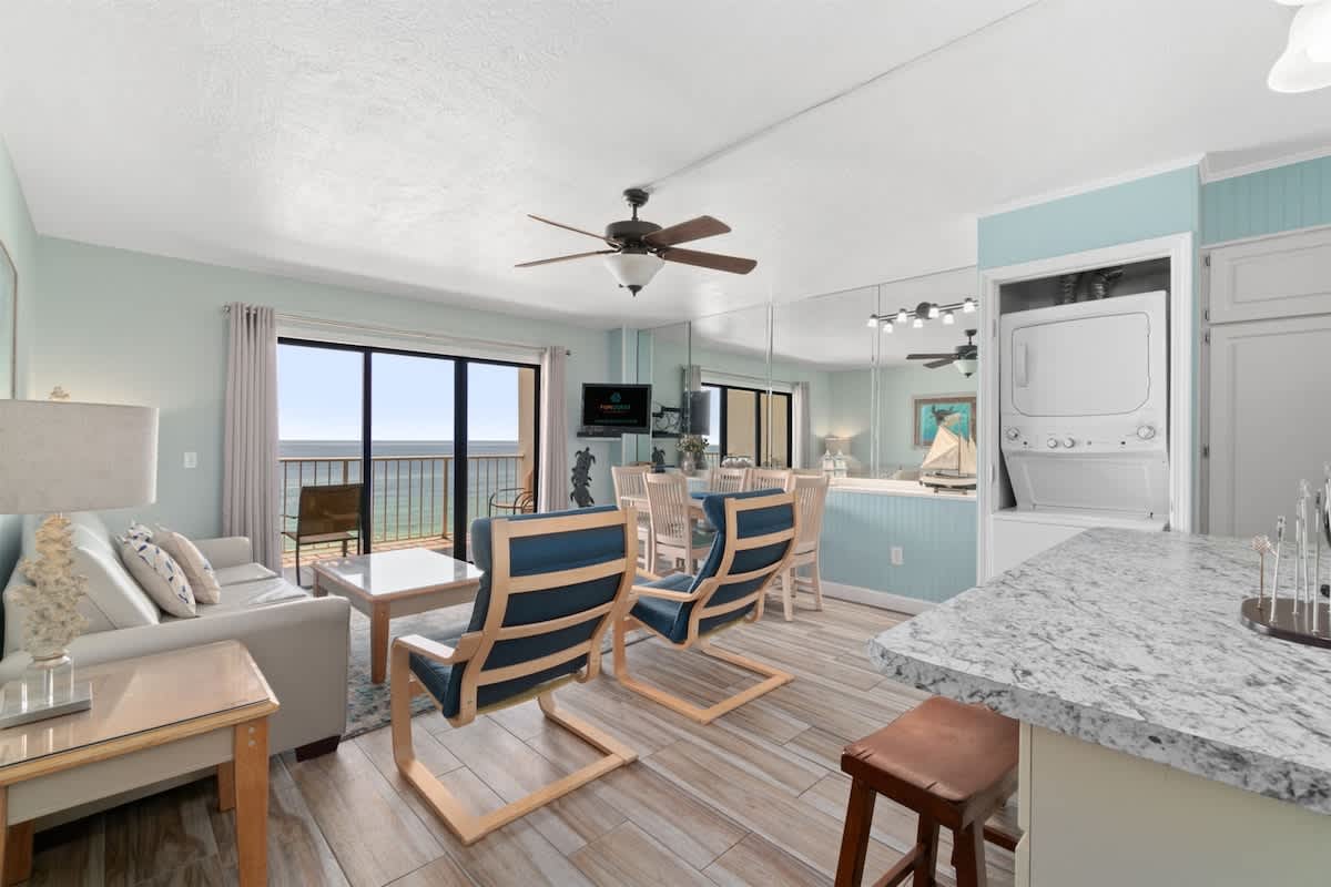 The Summit 1030 – Cozy living area with ocean view, dining table, and kitchen appliances visible.