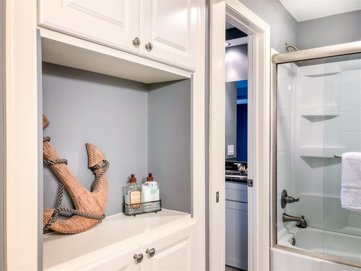 The Summit 611 – Bathroom with an anchor decoration, toiletries, and a glass shower enclosure.