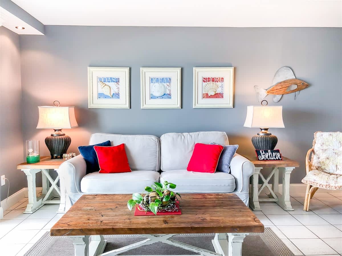 The Summit 611 – Cozy living room with gray walls, a light sofa, decorative pillows, and a wooden coffee table.