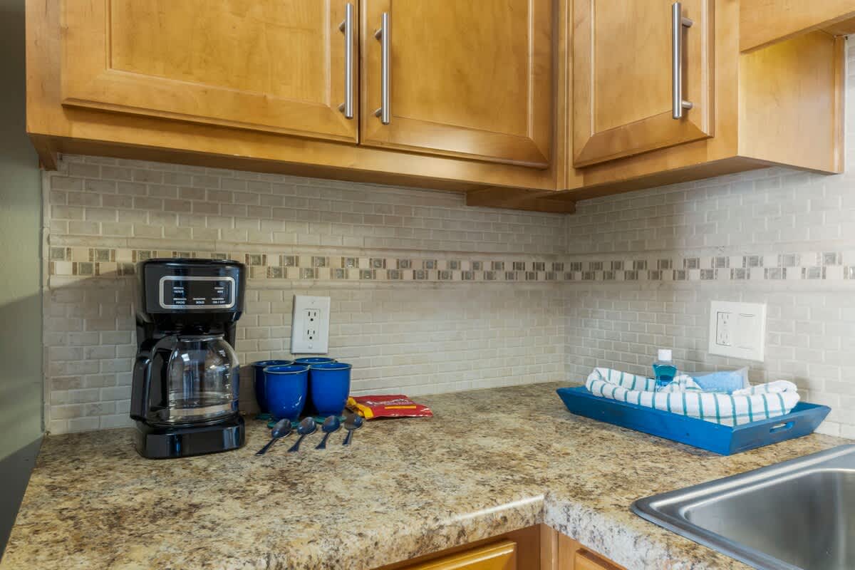 The Summit 1128 – Interior kitchen counter with coffee maker, blue cups, spoons, and a tray with a towel.