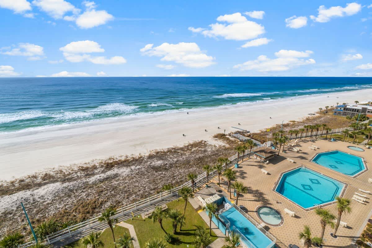 The Summit 1128 – View of beach, ocean, and swimming pools from a balcony.