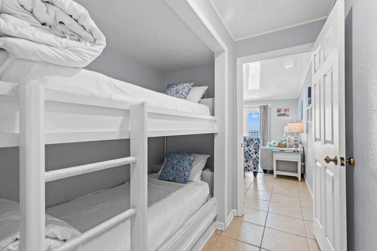 The Summit 1409 – Bunk beds with pillows, hallway leading to a living area with a view.