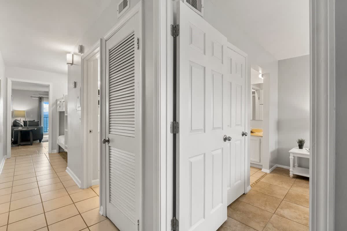 The Summit 620 – Entrance hallway with open doors to living area and bathroom, tiled floor, and neutral decor.