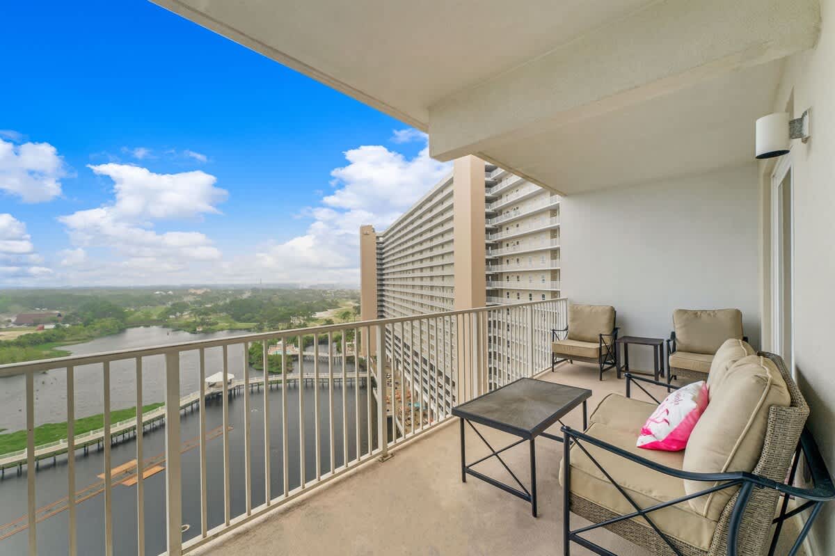 Laketown Wharf 1331 – Balcony with seating, overlooking a waterway and distant landscape.