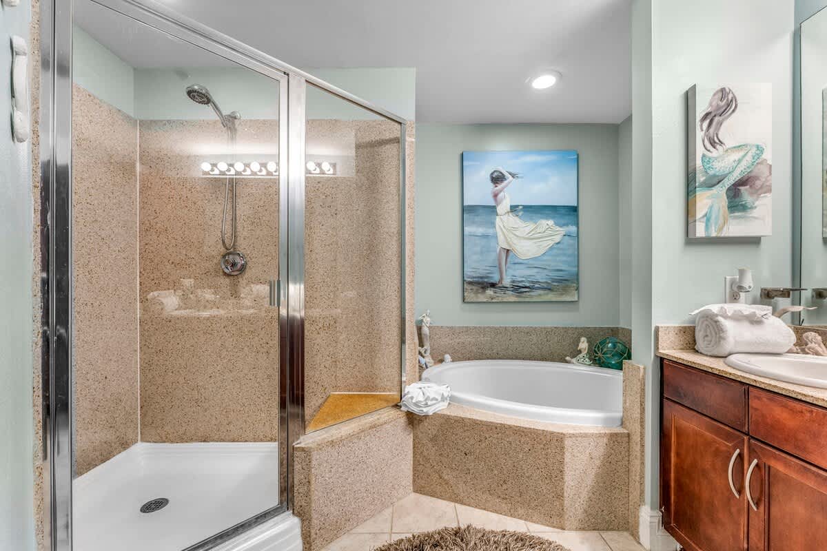 Laketown Wharf 1331 – Bathroom with walk-in shower, soaking tub, and decorative beach-themed artwork.
