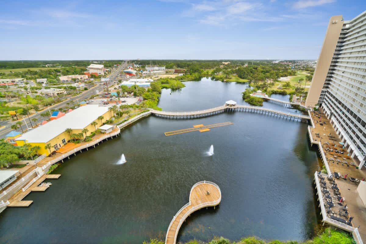 Laketown Wharf 1331 – Aerial view of a lake with fountains, wooden docks, and nearby buildings.