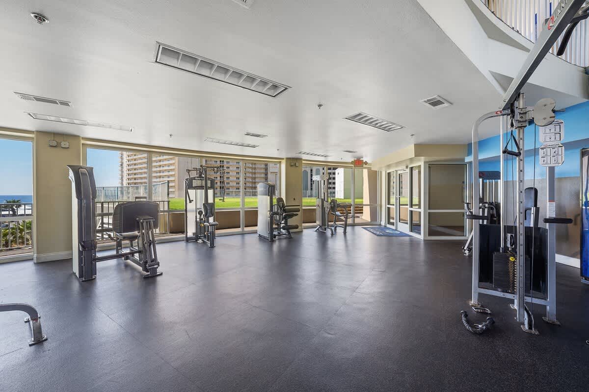 Laketown Wharf 1331 – Gym with fitness equipment and large windows showing a view of the outdoors.