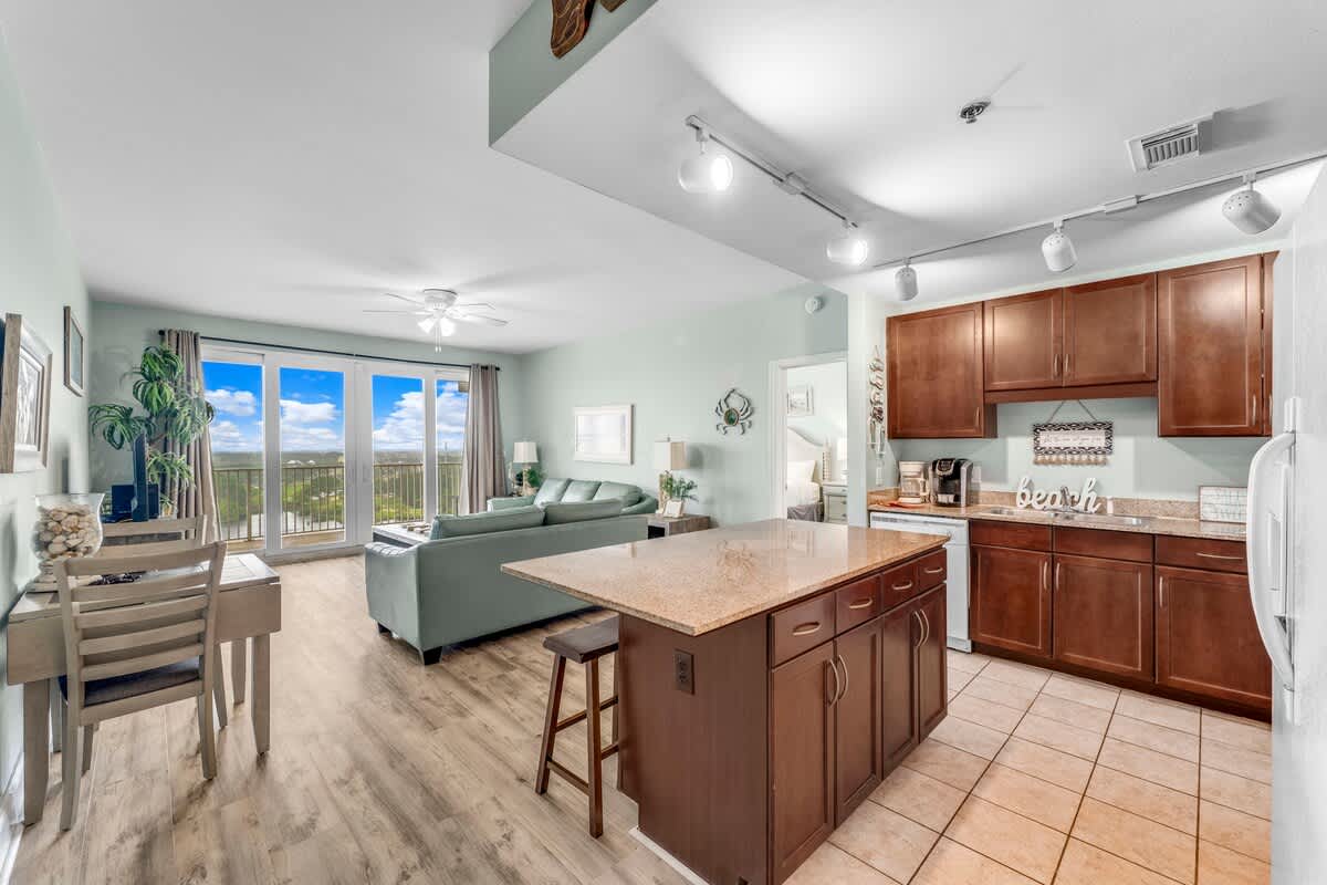 Laketown Wharf 1331 – Modern living room and kitchen with large windows overlooking scenic views.