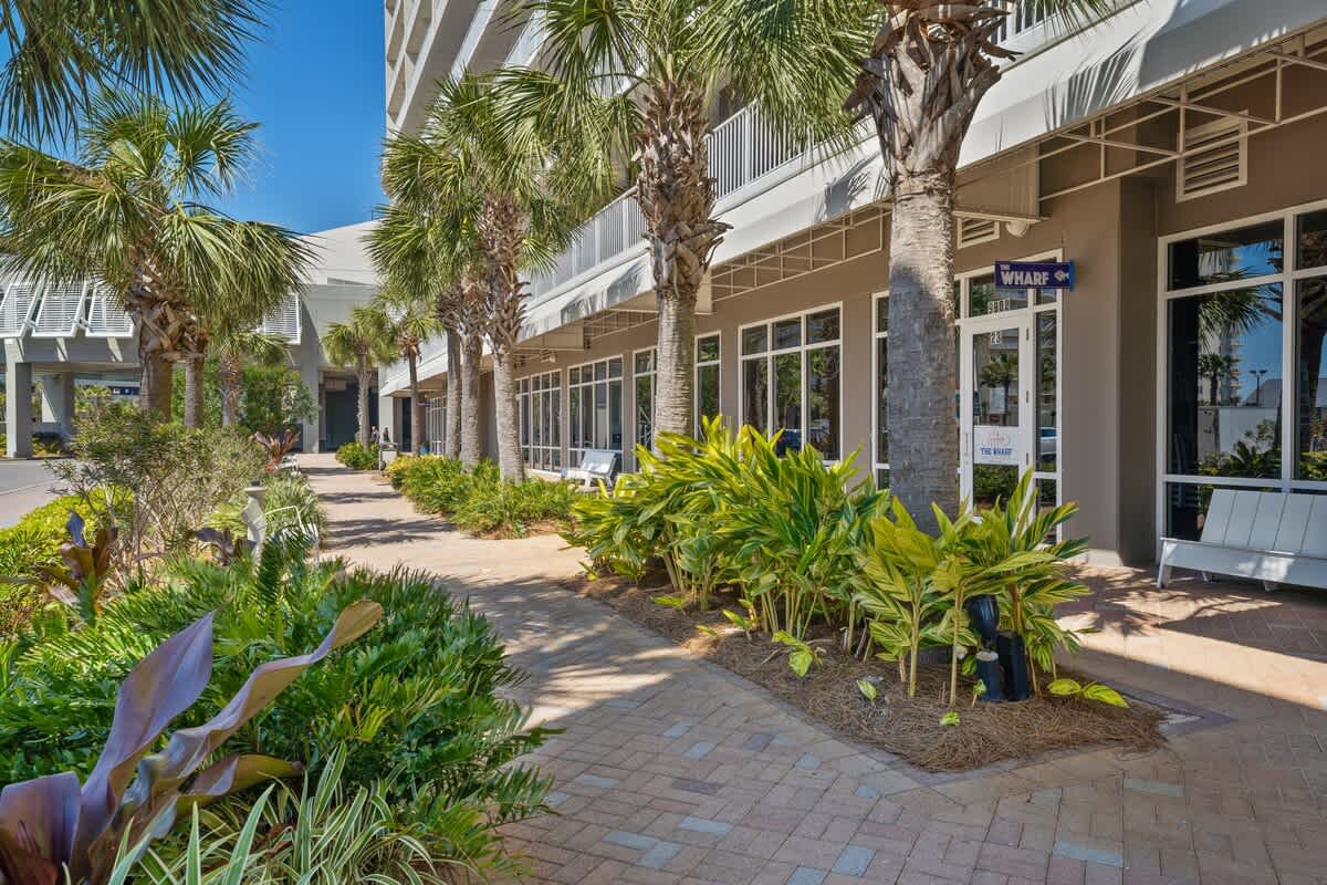 Laketown Wharf 1331 – Exterior view of Laketown Wharf with palm trees, plants, and walkway beside the building.