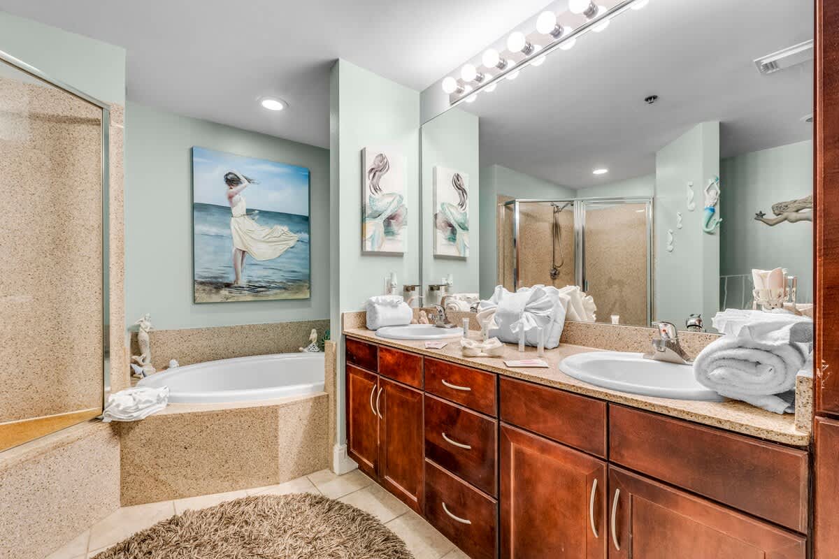 Laketown Wharf 1331 – Spacious bathroom with double vanity, soaking tub, and separate shower, adorned with decorative artwork.