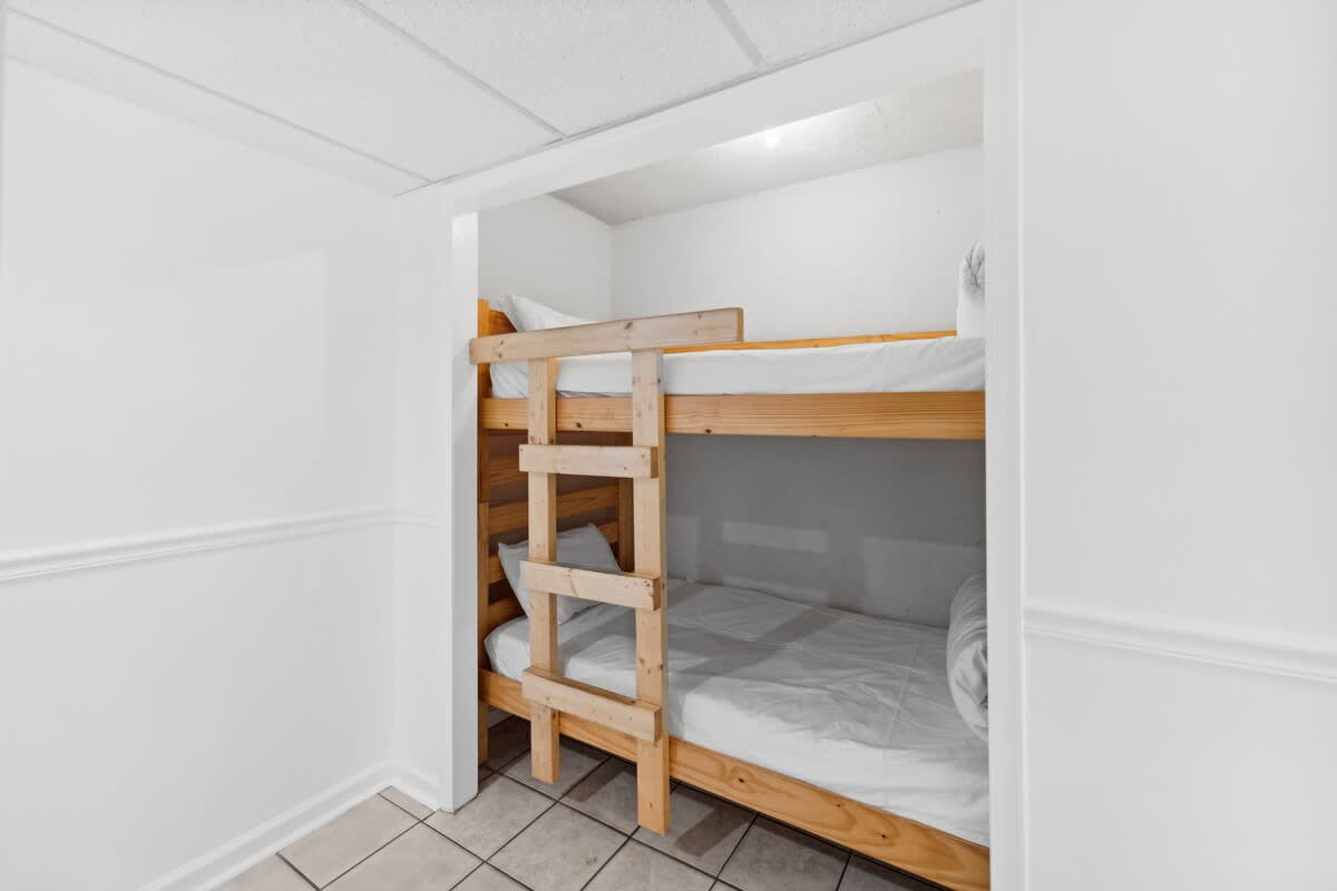 Moondrifter 608 – Bunk bed in a small room with white walls and tile flooring.