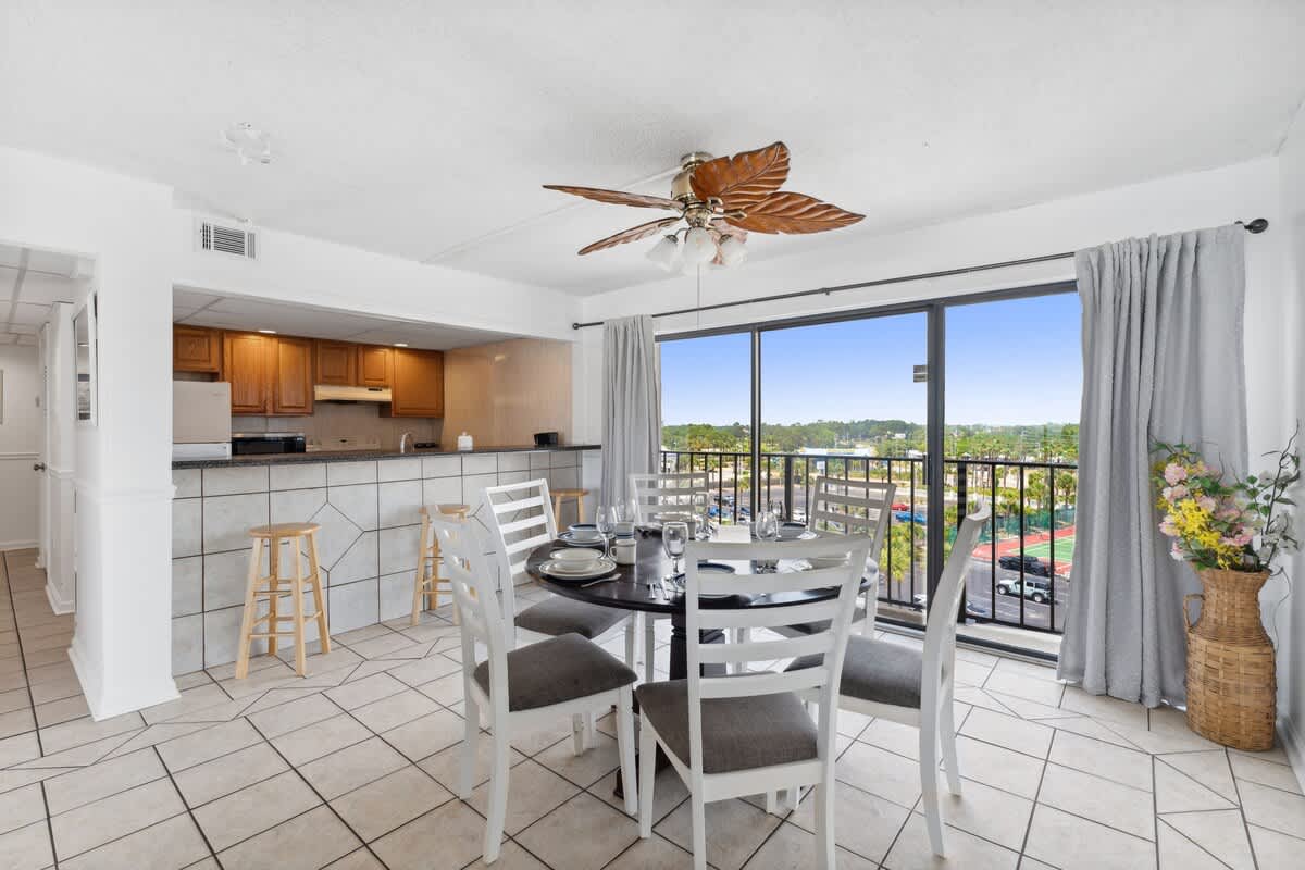 Moondrifter 608 – Dining area with a round table, kitchen view, and large window showcasing an outdoor landscape.