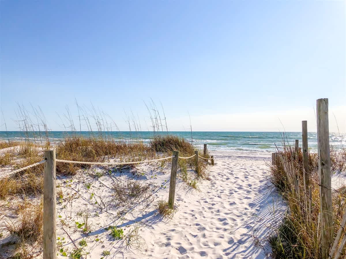 5218 Beach Dr A – Pathway of white sand leading to the beach with ocean view and tall grasses.
