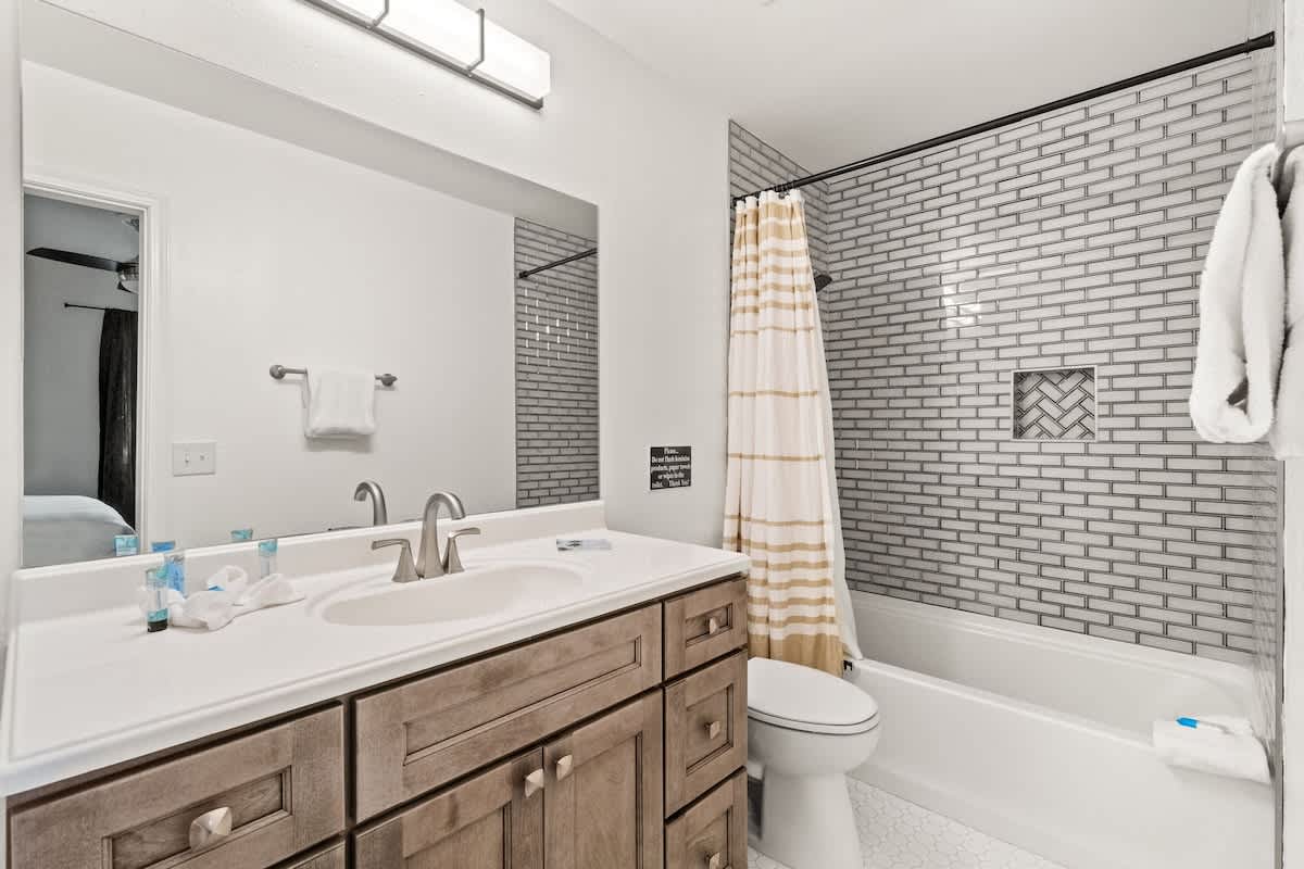 5218 Beach Dr A – Modern bathroom with a double sink vanity, shower, and bathtub. White and gray tile design.