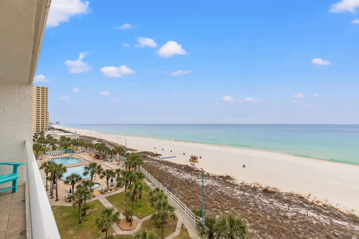 The Summit 701 – View of sandy beach, ocean, and pool area from balcony of vacation rental.
