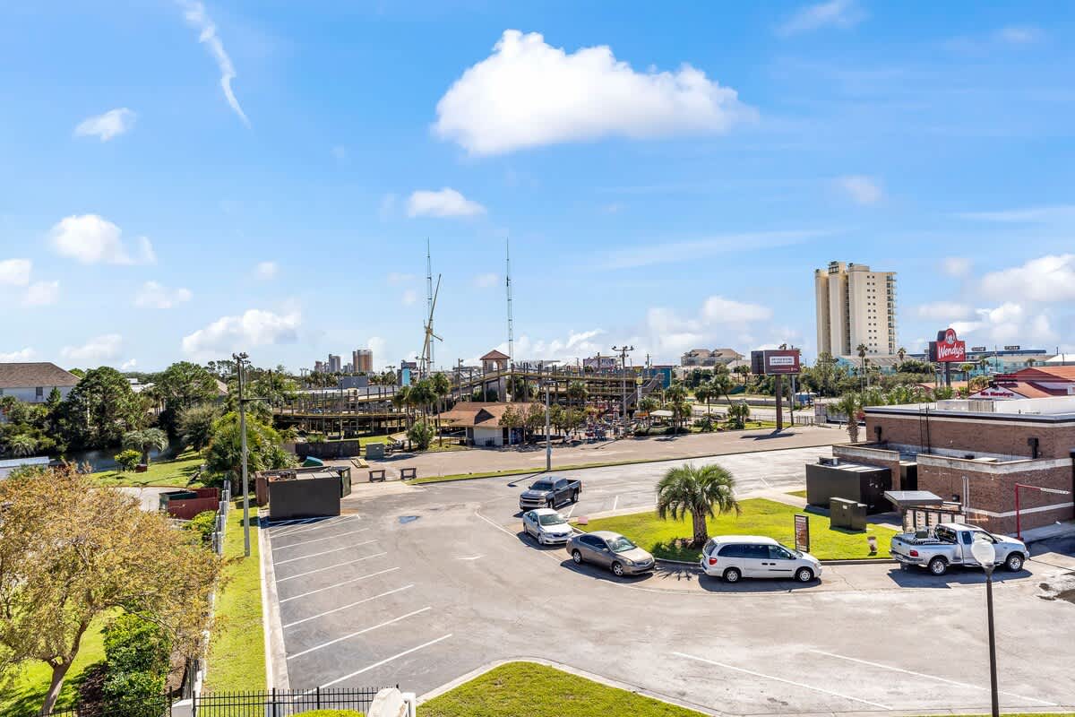 St Thomas SQ 1302B – View from balcony featuring a parking lot, nearby buildings, and a clear blue sky.