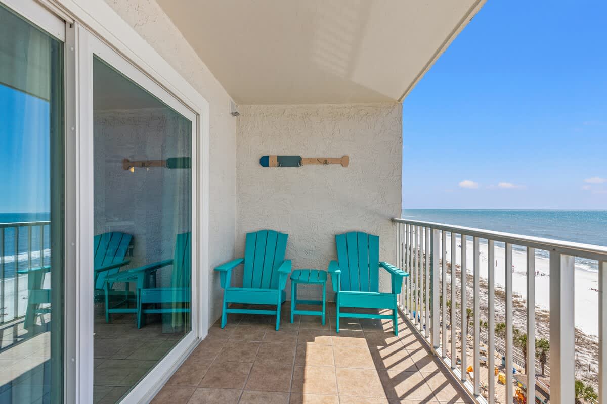 The Summit 1011 – Balcony with turquoise chairs overlooking the beach and ocean.