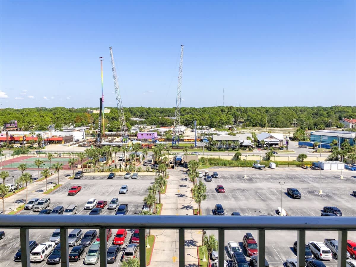 The Summit 618 – View from balcony showing a parking lot, nearby attractions, and construction cranes in the background.