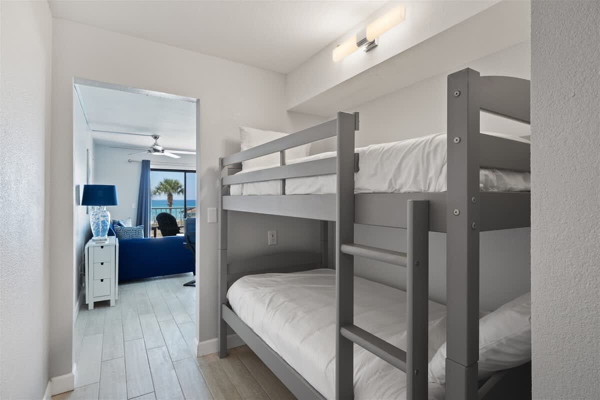 The Summit 220 – Bunk bed in a hallway, with a view of a living area and ocean beyond.