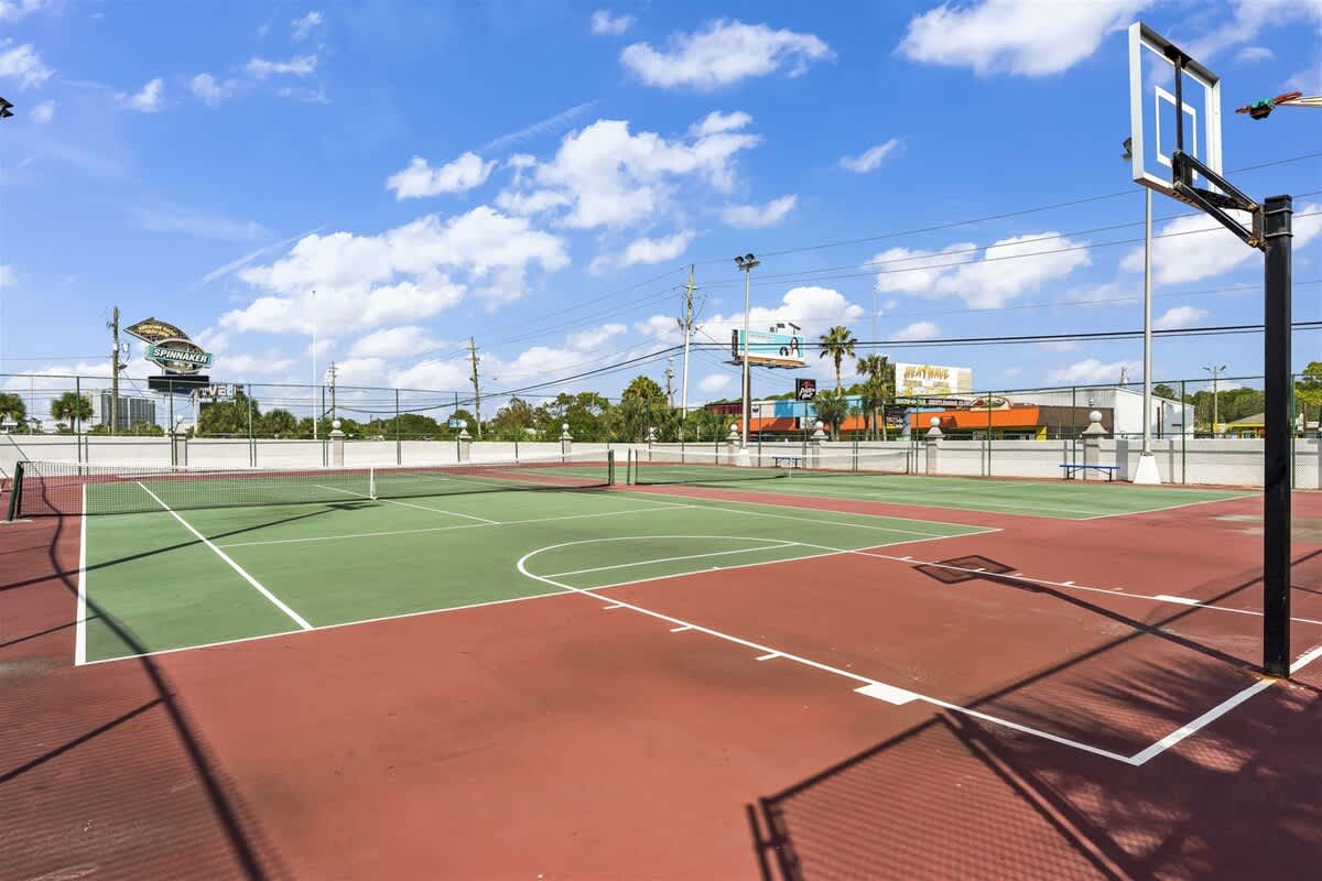 The Summit 206 – Outdoor sports court with tennis net and basketball hoop, surrounded by palm trees and buildings.