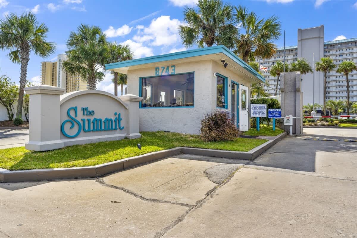 The Summit 206 – Entrance of The Summit featuring a reception area and palm trees in a sunny setting.