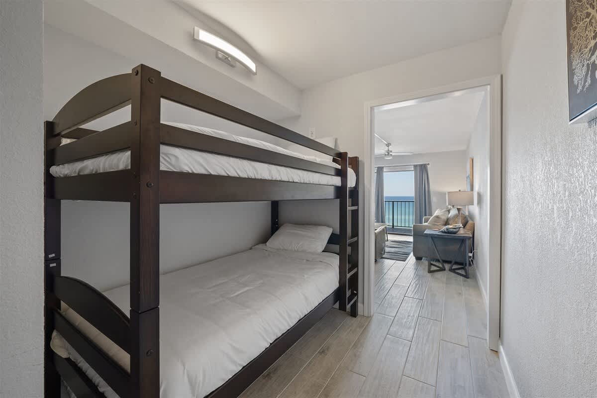 The Summit 621 – Bunk beds in a hallway leading to a small living area with ocean view.