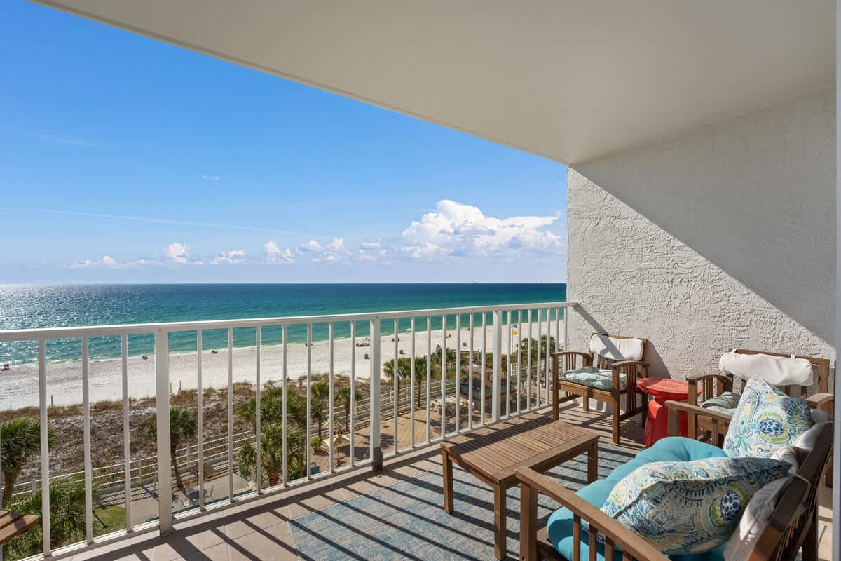 The Summit 624 – Balcony with ocean view, seating area, and sandy beach below.