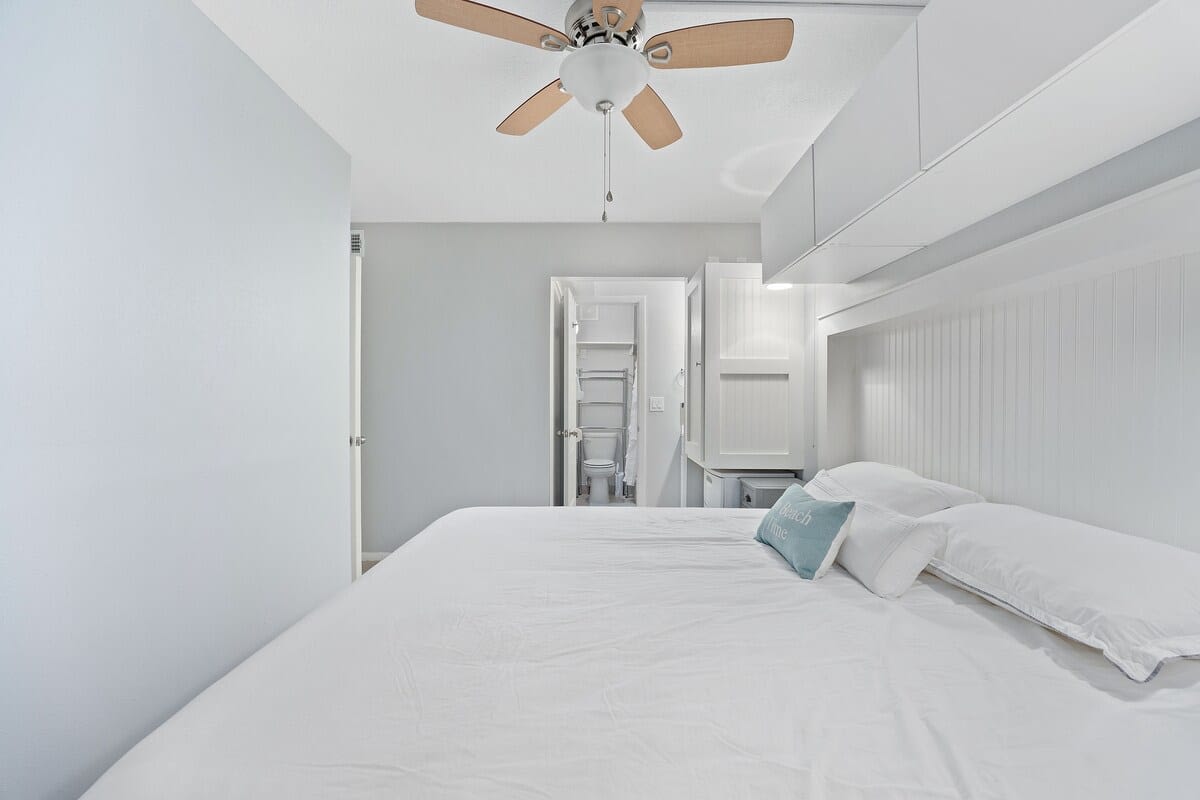 The Summit 624 – Bedroom with a king-sized bed, ceiling fan, and bathroom entrance visible in the background.