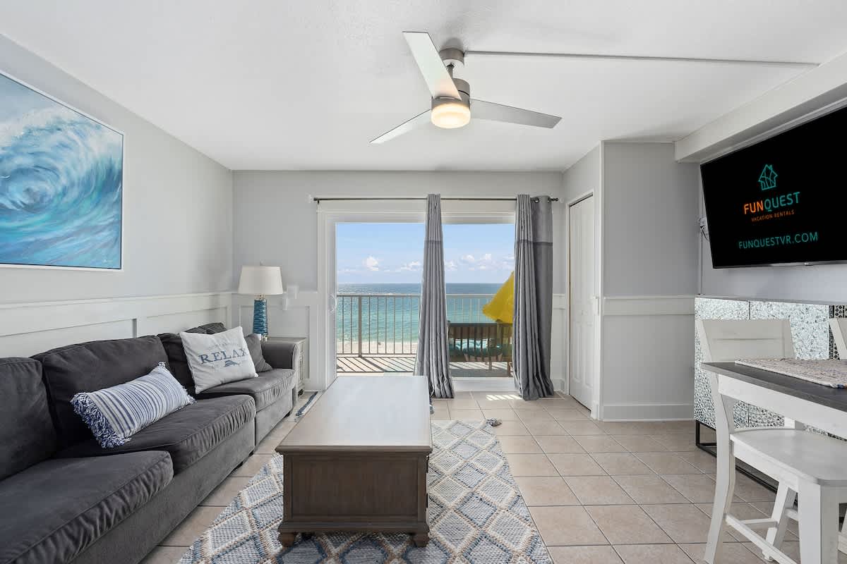 The Summit 624 – Living room with ocean view, sofa, coffee table, and dining area.