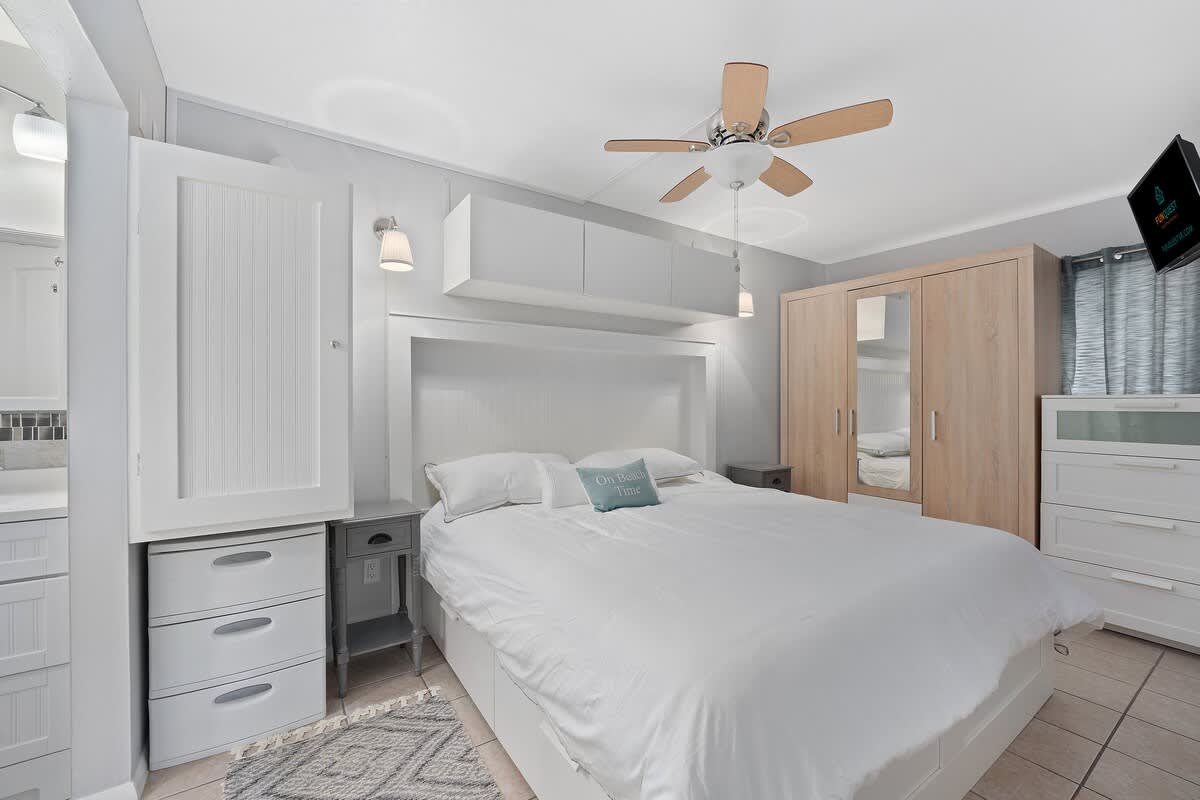 The Summit 624 – Bedroom with a queen bed, dresser, nightstand, and ceiling fan.