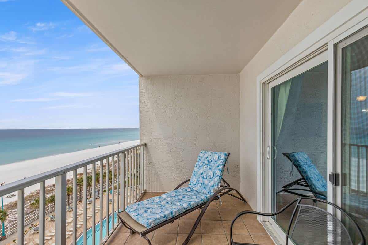 The Summit 820 – Balcony with beach view, lounge chair, and sliding glass door to the room.