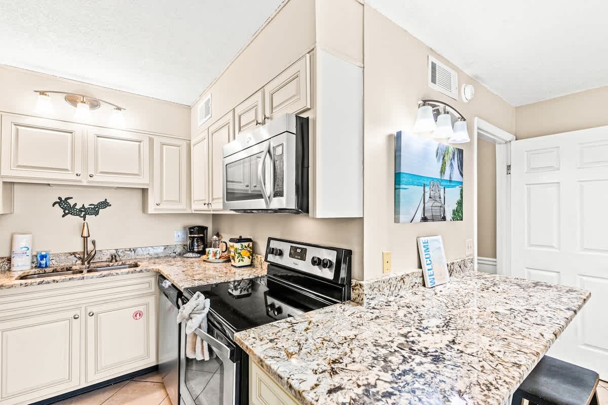 The Summit 820 – Modern kitchen with granite countertops, stainless steel appliances, and bar seating in a vacation rental.