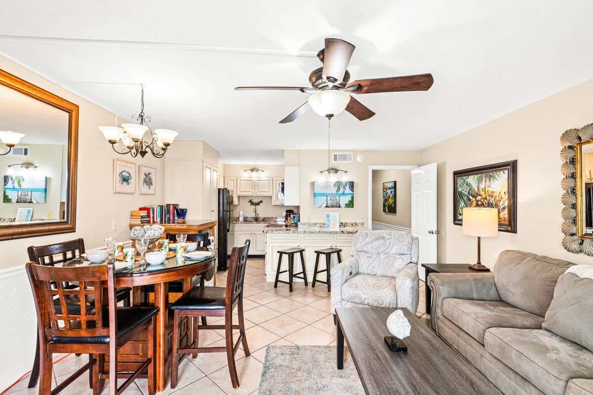 The Summit 820 – Living room and dining area with a round table, couch, and kitchen in light-colored decor.
