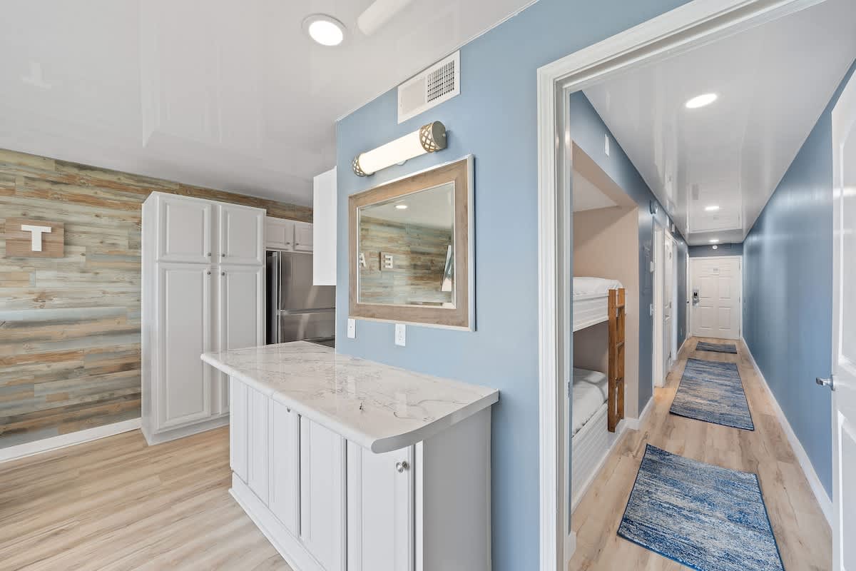 The Summit 1408 – Interior of a vacation rental showing a kitchen, hallway, and bunk beds against blue walls.