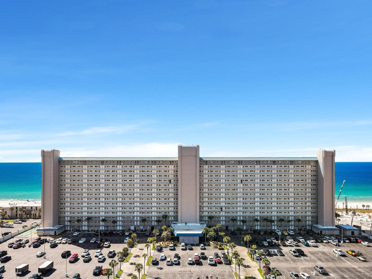 The Summit 726 – Exterior view of The Summit 726, a beachfront condominium with multiple stories and a parking lot.
