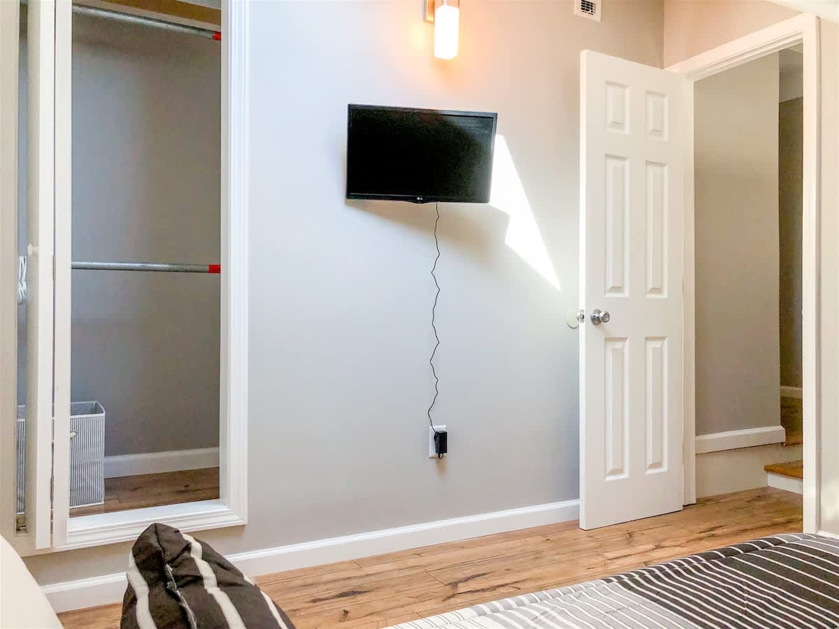 5218 Beach Dr B – Bedroom with a wall-mounted TV, closet, and a view of a doorway.